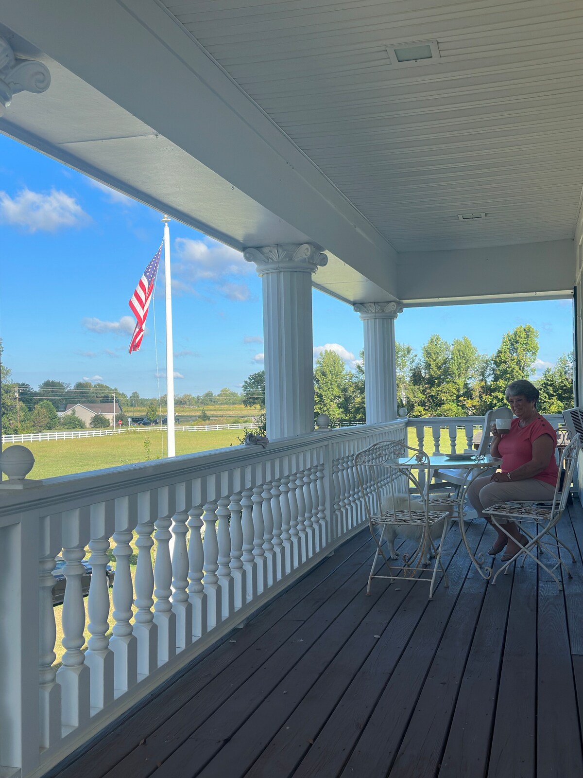 Guest enjoying coffee on the upstairs porch at Parkton Place