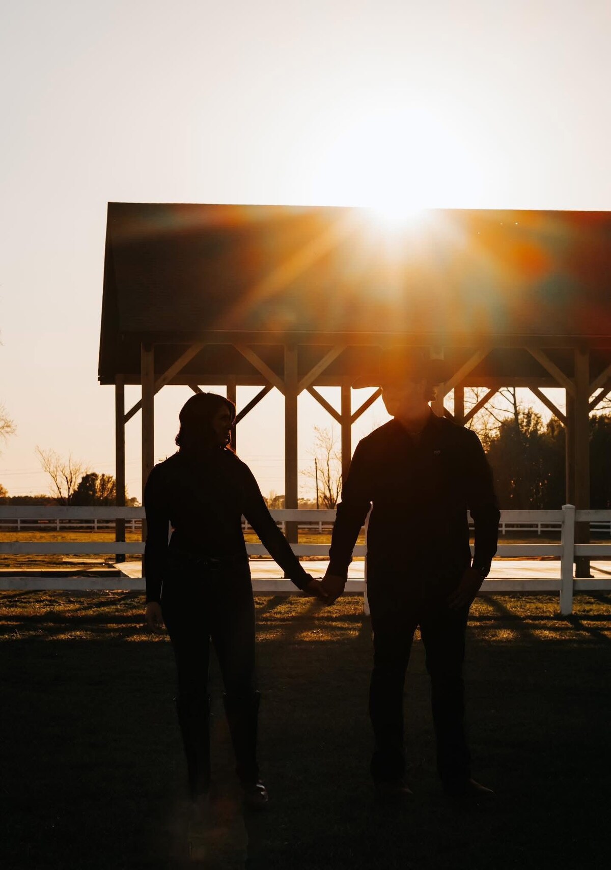 Couple silhouetted at sunset by the pavilion at Parkton Place