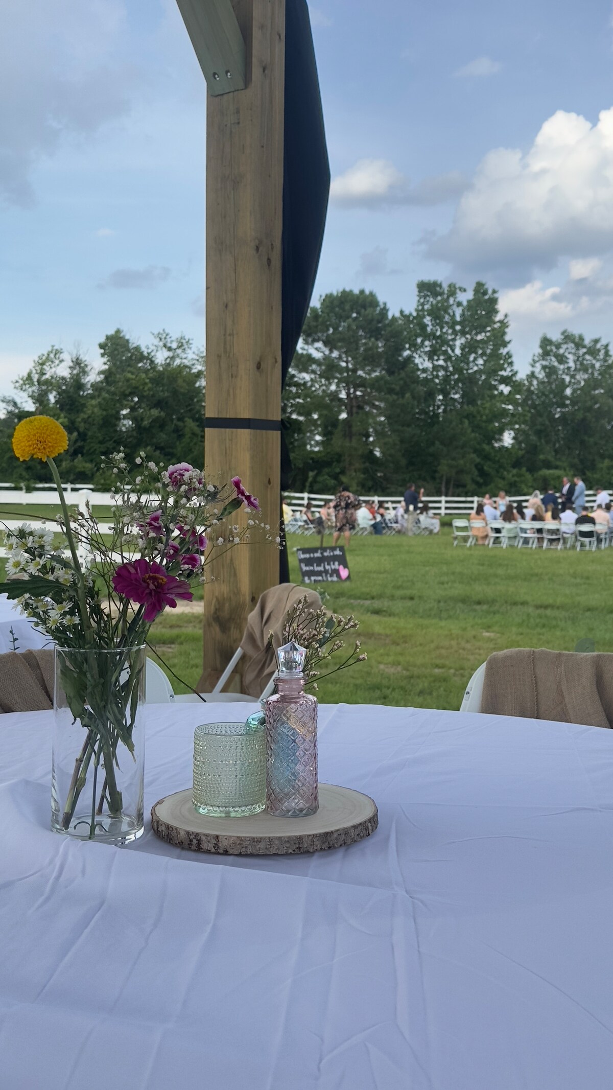 Wedding ceremony in progress at Parkton Place, wildflower centerpiece in foreground